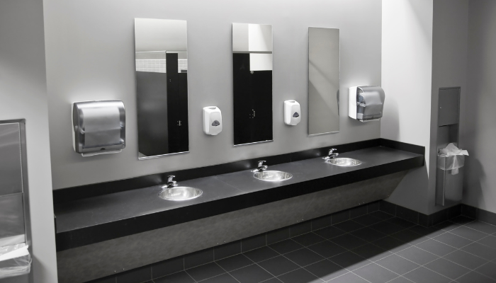 Commercial restroom with dispensers and waste units